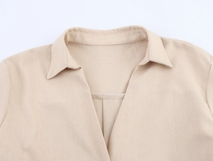 Detail of V-neckline and textured linen fabric on beige casual long sleeve shirt