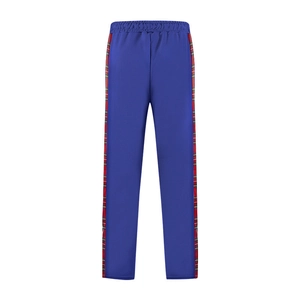 Detail of royal blue joggers featuring red and green plaid side stripes and elastic waist