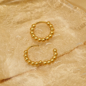 Boucles d'oreilles créoles dorées à billes pour femmes avec des sphères métalliques
