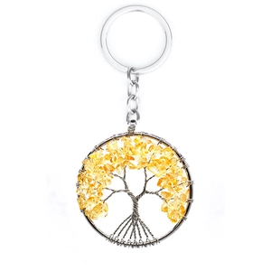 Detail of silver tree of life keychain featuring yellow crystal stones and metal wire art