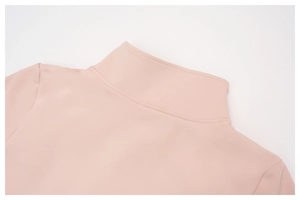 Détail du col montant rose d'un haut de sport avec coutures précises et tissu thermique doux