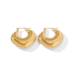Close-up of chunky gold hollow heart earrings with a high-polished mirror finish