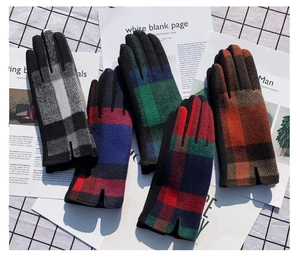 Detail showing multi-color plaid winter gloves with touchscreen fingertips on wool fabric