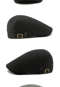 Detail view of black beret cap with cotton twill texture and bronze side metal buckle