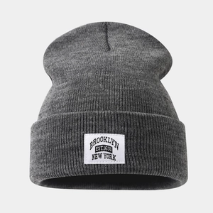 Dark grey Brooklyn knit beanie with cuffed design and white rectangular patch for men and women