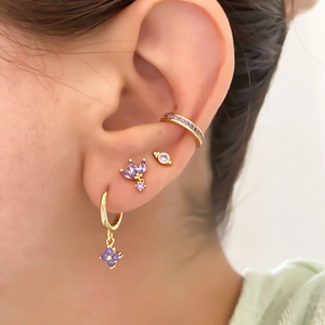 Gold-plated hoop earrings and ear cuffs set with purple zircons worn on model ear