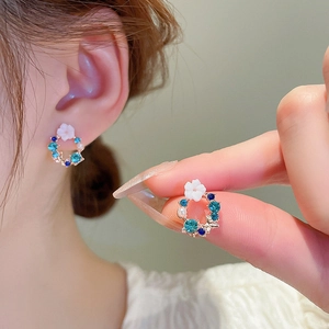 Floral wreath earrings featuring blue crystals, white flowers and pearls on gold base