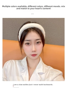 Close-up of a white plush headband with a soft fluffy texture worn by a model