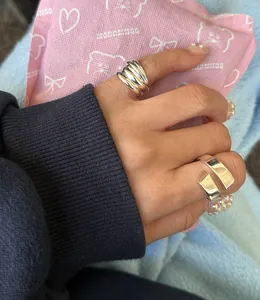 Close-up of minimalist S925 silver layered rings on finger with multi-wrap design
