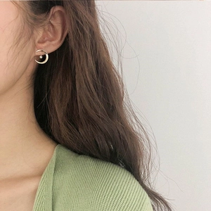 Détail de boucles d'oreilles lune dorées avec zircon porté par un mannequin femme