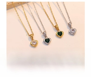 Detail of titanium steel heart pendant necklaces in emerald green and white gemstone