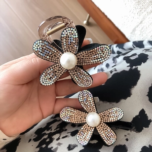 Detailed macro of crystal sunflower hair claw clip with rhinestones and central pearl