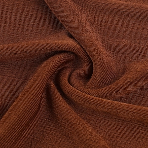 Macro close-up of brown knit fabric showing detailed ribbed texture and soft material structure