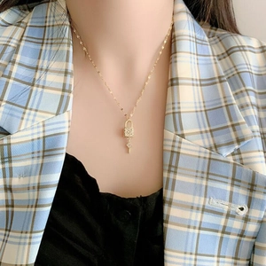 Fashionable gold titanium steel necklace with elegant lock and key pendants on a model