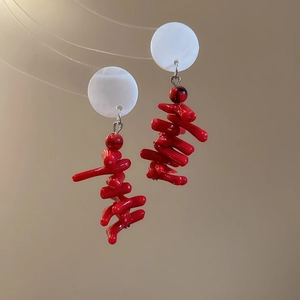 Detail of red coral-style branch tassels and white shell beads on vintage earrings