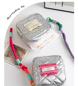 Détail d'une trousse de maquillage en PU argenté matelassé avec cordon et rangement