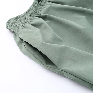 Dettaglio dei pantaloni cargo con elastico in vita, coulisse e tasca laterale