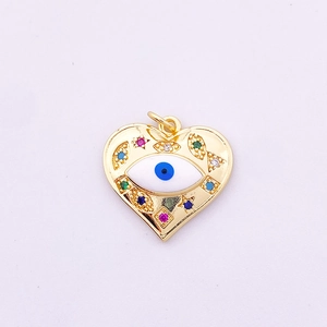 Macro shot of gold heart pendant with evil eye motif and colorful zircon inlay