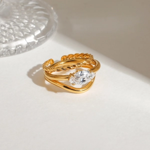 Macro view of gold plated layered ring with marquise zircon on a textured pedestal