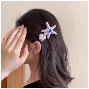 Detailed view of sea star hair clip with pink starfish, pearl and shell on model
