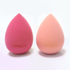 Detail of tear-drop makeup sponges in rose and orange, showcasing fine porous texture