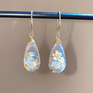 Vista detallada de pendientes de resina en forma de gota con flores secas reales