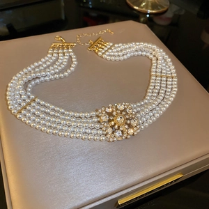 Close-up of luxury multilayer pearl necklace with gold rhinestone square clasp on jewelry box