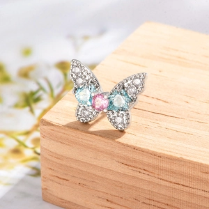 Sparkling copper butterfly cartilage earring with colorful cubic zirconia on wood
