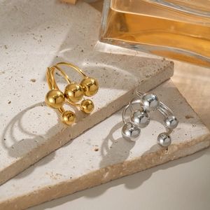 Minimalist geometric stainless steel open rings in gold and silver on a stone base