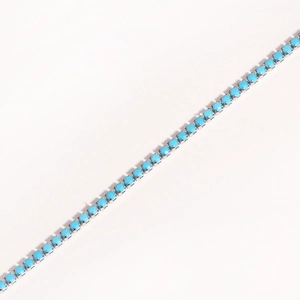 Detail of silver chain bracelet featuring round turquoise stones in a prong setting