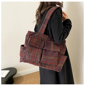 Detailed side view of a large plaid lamb wool tote bag with functional pockets