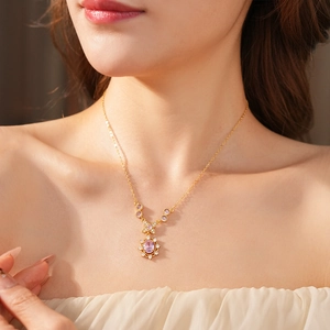 Macro shot of a vintage gold necklace featuring a pink oval gemstone pendant with crystals