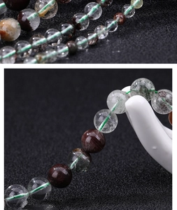 Macro detail of natural green phantom crystal beads with dark brown accent beads on cord