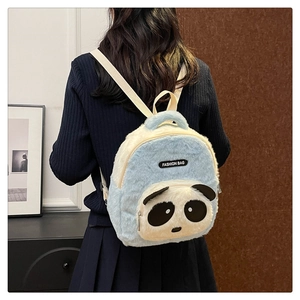 Detalle de la mochila de panda de peluche en azul y beige con etiqueta de moda