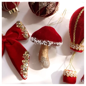 Detailed view of burgundy velvet Christmas ornaments with gold sequins and mushroom shapes