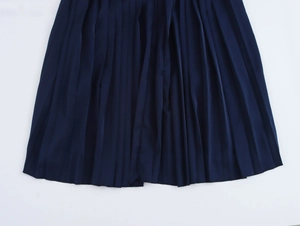 Detail of elegant navy blue pleated satin maxi dress showing fabric texture and hemline