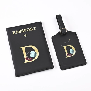 Detail of black PU leather passport holder and luggage tag set with golden letter D