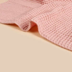 Detail shot of soft pink cotton waffle texture fabric with neat stitching edge for nursing