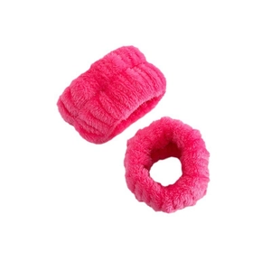 Close-up of plush pink coral fleece wristbands for washing face and absorbing water