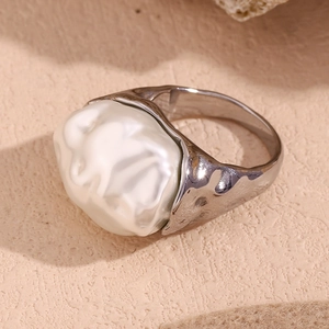 Macro shot of a silver stainless steel ring with a large white irregular shell stone
