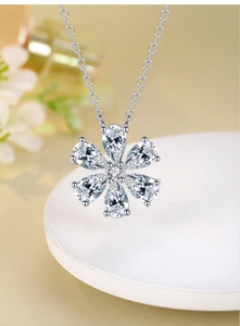 Macro shot of silver six-petal flower necklace with shimmering teardrop zircons