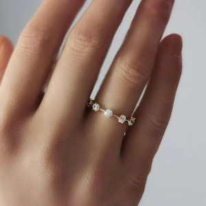 Close-up of minimalist gold plated slim ring with micro-pave round cubic zirconia on finger