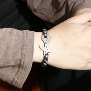 Macro shot of stainless steel wrench and hammer tools bracelet on male wrist