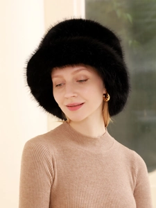 Détail d'un bob en fausse fourrure noire avec une texture pelucheuse épaisse pour l'hiver