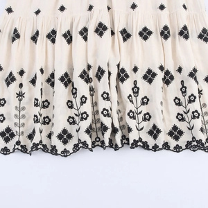Bohemian V-neck embroidered maxi dress featuring geometric patterns and wavy hemline