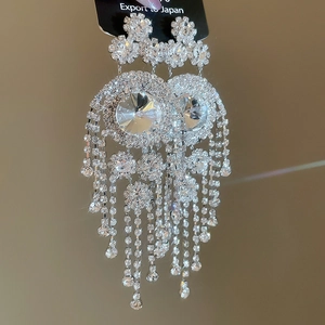 Macro shot of sparkling crystal tassel earrings with elegant floral rhinestone clusters