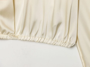 Vue détaillée de l'ourlet élastique d'un chemisier en satin champagne pour femme