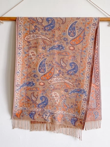 Close-up of brown ethnic paisley scarf featuring colorful fringe and soft texture