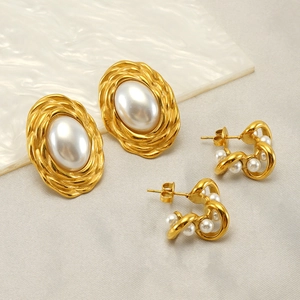 Macro shot of vintage 18K gold plated earrings with pearls on white marble background
