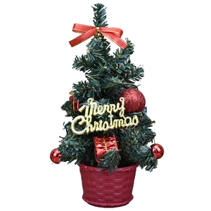 Mini desktop Christmas tree with red ribbons, ornaments and a woven basket base
